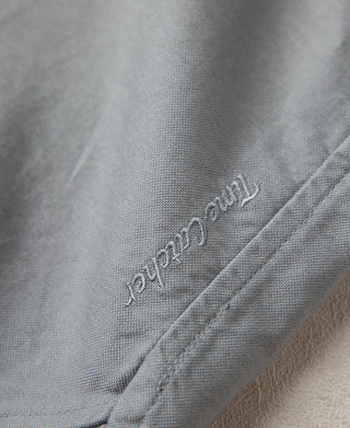 Close-up of small logo embroidery on gray oxford fabric
