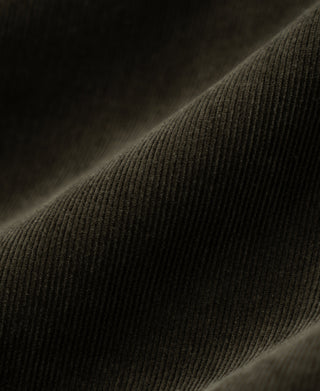 Dark green corduroy fabric close-up showing fine ribbed texture