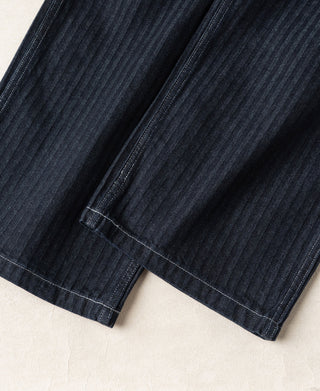 Indigo herringbone denim pants leg with straight hem and vertical seam stitching