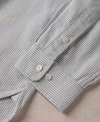 Oxford shirt cuff close-up, blue-and-white stripes with two buttons.