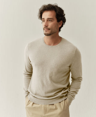 Front detail view of an apricot merino wool crewneck sweater with refined knit construction