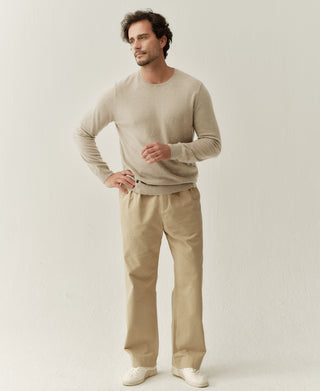 Man wearing an apricot merino wool crewneck sweater with a soft minimalist fit