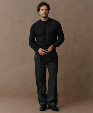 Man wearing a black merino wool mock neck sweater with a refined minimalist style and tailored silhouette