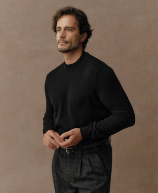 Side view of a black merino wool mock neck sweater showing the clean fit and premium wool texture