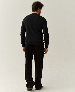 Back view of a black merino wool sweater highlighting the clean knit structure and classic design