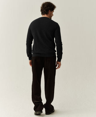 Back view of a black merino wool sweater highlighting the clean knit structure and classic design