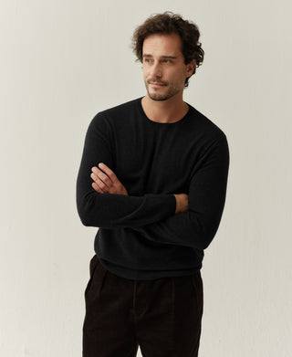 Close-up view of a black merino wool sweater showing its soft knit texture and refined silhouette