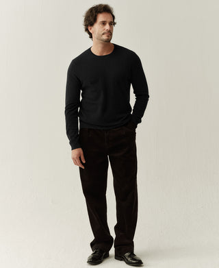 Man wearing a black merino wool crewneck sweater with a clean minimalist fit