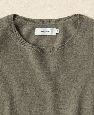 Gray-green merino wool crewneck sweater with ribbed neckline and size tag.