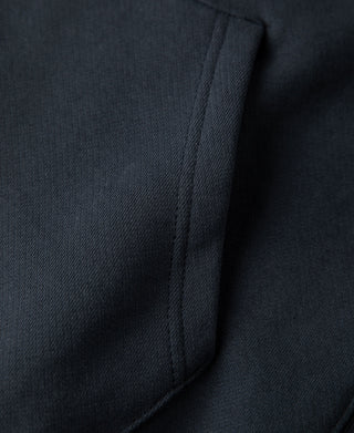 Detailed view of the kangaroo pocket edge and stitching on the dark blue hoodie