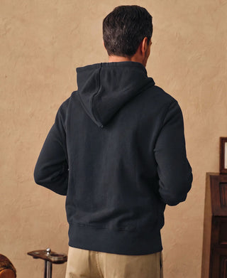 Back view showing the hood and relaxed silhouette of the dark blue hoodie