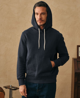 Front lifestyle view of a man wearing the dark blue heavyweight cotton hoodie