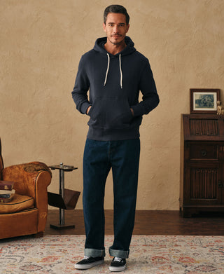 Full lifestyle view of a man wearing the dark blue heavyweight cotton hoodie with denim jeans