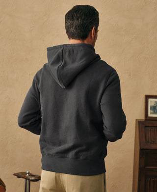Back view showing the hood and relaxed silhouette of the dark gray hoodie