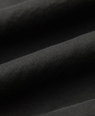 Front lifestyle view of a man wearing the dark gray heavyweight cotton hoodie