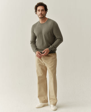 Man wearing a grayish green merino wool crewneck sweater with a clean minimalist silhouette