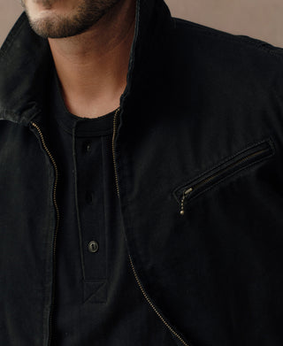 Black duck canvas cossack jacket close-up: front zip, snap placket, yellow stitching