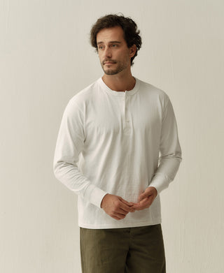 White long-sleeve henley shirt with button placket, worn by model front view.