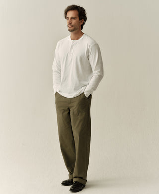 White long-sleeve henley shirt with short button placket, side profile view.