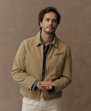 Washed khaki cossack jacket with chest pocket and snap front, over denim shirt