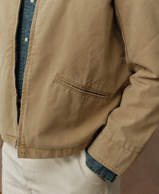 Washed khaki cossack jacket sleeve and side pocket detail over white pants