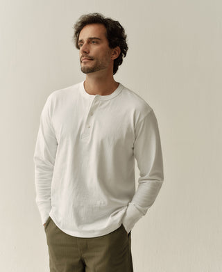 White long-sleeve henley shirt with buttoned placket and crew-style neckline.