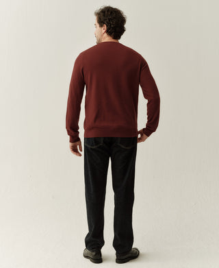Back view of a jasper red merino wool sweater highlighting the simple design and smooth knit finish