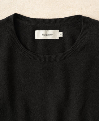 Black merino wool crewneck sweater neckline with Tame Catcher label.