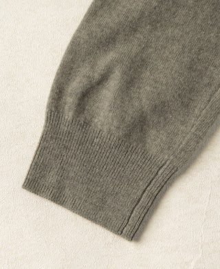 Gray-green merino wool sweater sleeve cuff with ribbed knit edge.
