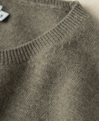 Gray-green merino wool crewneck sweater showing ribbed collar and knit texture.