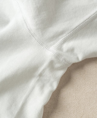 Detailed view of the sleeve seam and smooth loopwheel cotton texture on a vintage-inspired Henley shirt.