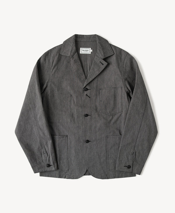 Black chambray work jacket with pointed collar, button front, and chest flap pockets