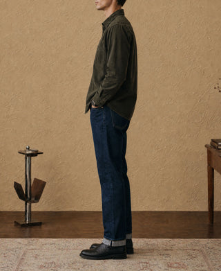 Dark green cotton corduroy work shirt with button front and long sleeves, side profile