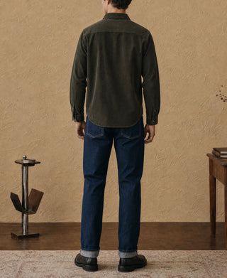 Back view of dark green corduroy work shirt with buttonless yoke and long sleeves