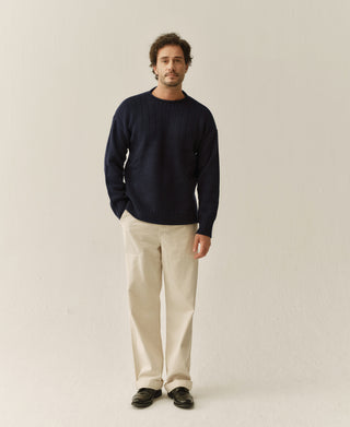 Navy Guernsey sweater worn with cream trousers, front view
