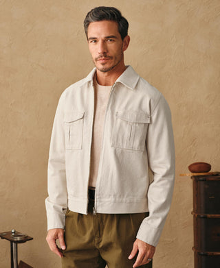 Natural twill jacket with stand collar, two flap chest pockets, and front zipper.