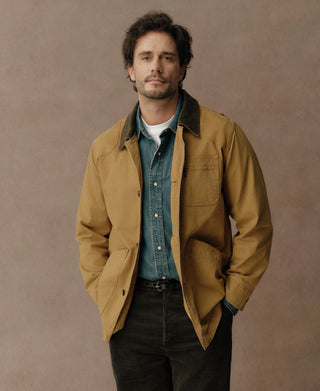 Khaki field jacket with dark corduroy collar, chest pocket, and two lower pockets.