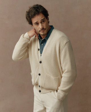 Natural cotton fisherman-rib cardigan worn with a shirt, showing its button front and ribbed sleeves
