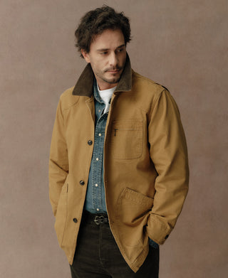 Khaki jacket with dark collar, button front, chest pocket, and angled lower pockets.