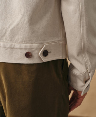 Natural twill jacket hem and cuff close-up with button and side seam stitching.