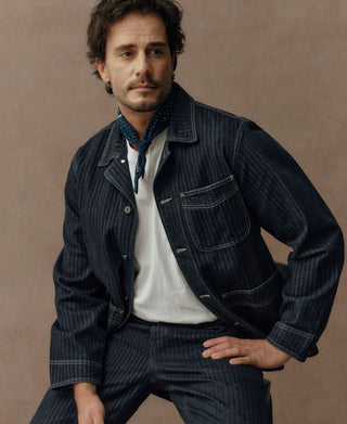 Indigo herringbone denim work jacket with flap pockets and button cuffs
