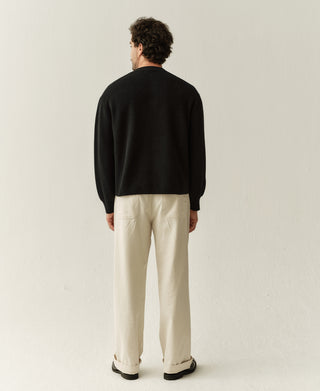 Men's black knit cardigan, back view with full length sleeves and ribbed hem