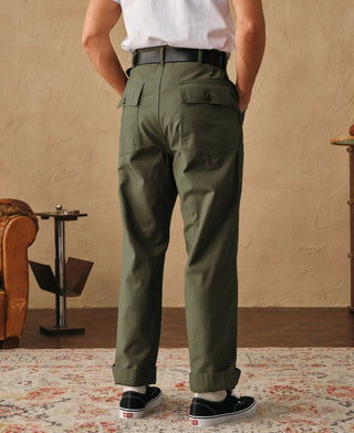 Olive fatigue pants with two back pockets, belt loops, and cuffed hem