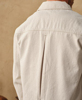 Back view of natural twill jacket with stand collar and center seam.