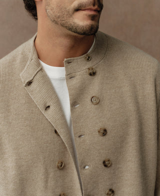 Close-up of ecru knit cardigan lapel and double-breasted buttons with brown hardware