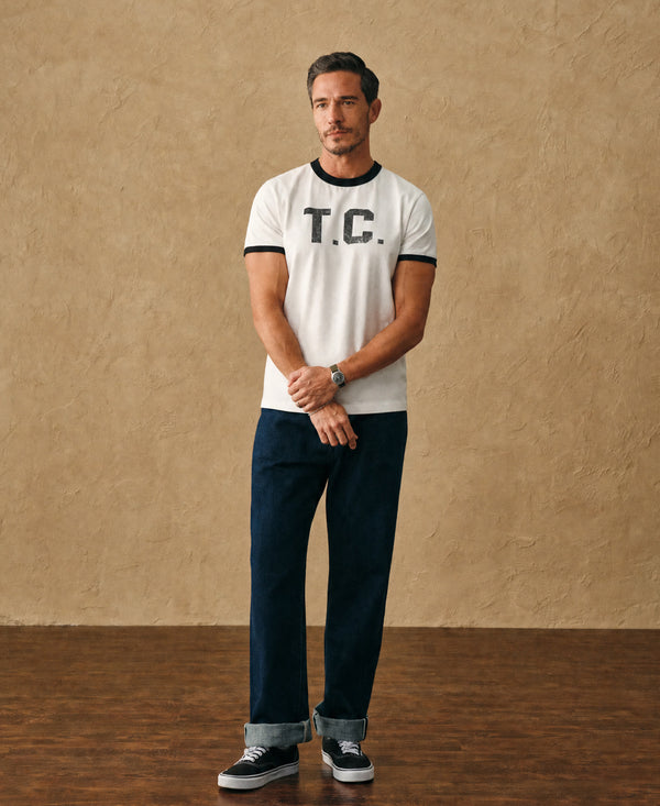 White ringer T-shirt with black trim and T.C. logo worn by a man