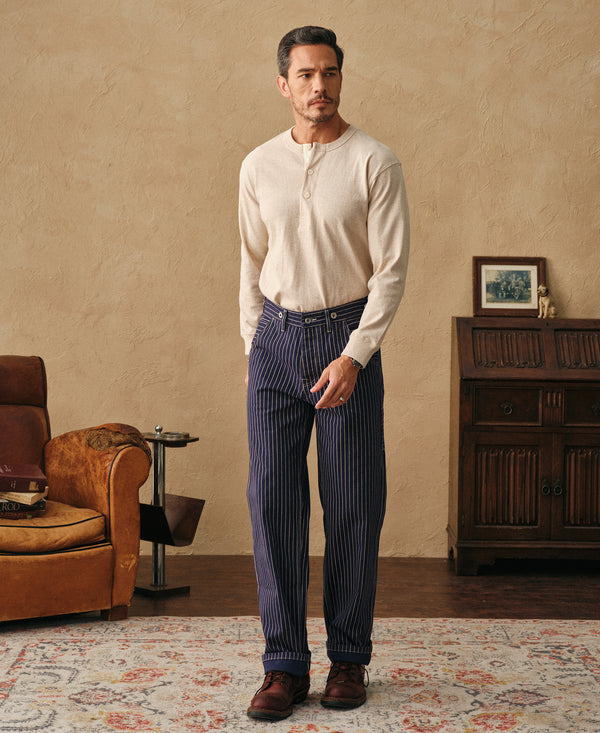 Indigo pinstripe work trousers worn front view, relaxed fit and belt loops