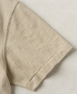 Apricot slub cotton T-shirt fabric close-up, visible seam stitching