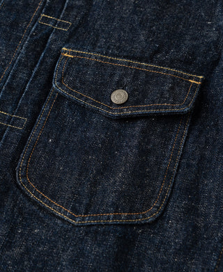 Close-up of a dark indigo denim pocket with a silver metal snap button.
